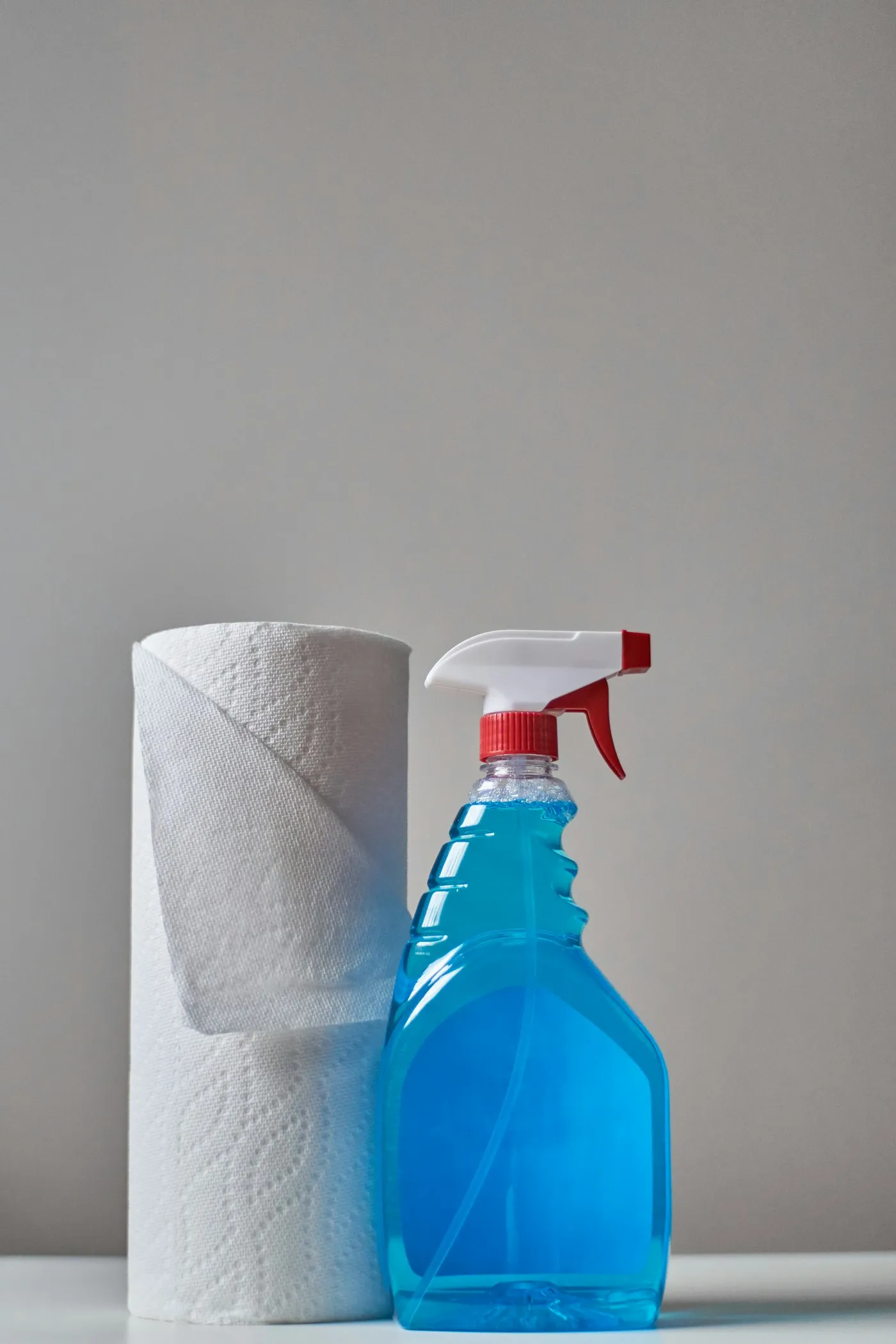 Blue cleaning spray and paper towels set out ready for a job
